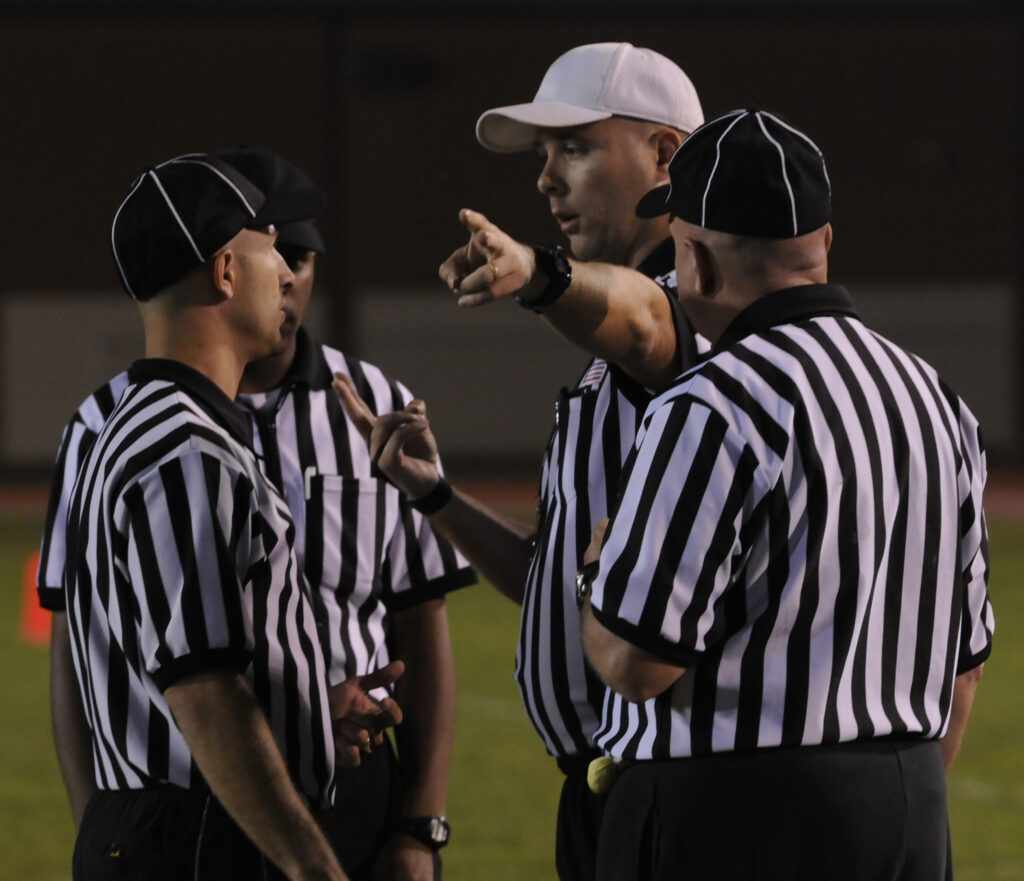 Referees discuss the flags thrown